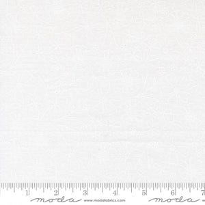 May include: White fabric with a floral pattern. The design features delicate white flowers and leaves embroidered on a white background. The fabric is measured with a ruler in inches.