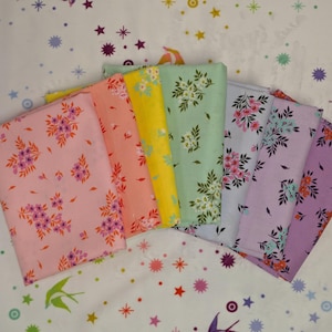 May include: A collection of folded fabric squares in various pastel colors, each adorned with a floral pattern. The colors include pink, peach, yellow, mint green, light blue, and lavender. The fabric is arranged in a fan shape, showcasing the different designs.