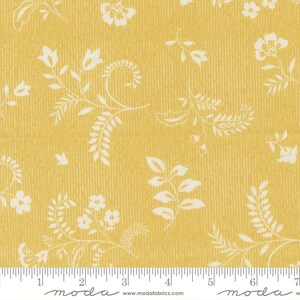 May include: Yellow fabric with a cream-colored floral pattern. The design features various flowers and leaves, with a textured background. The fabric is measured with a ruler in inches.