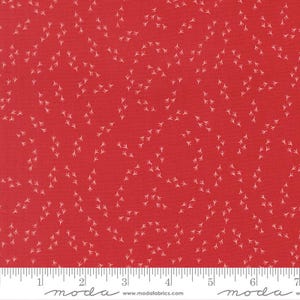 May include: Red fabric with a repeating pattern of small, white bird footprints. The fabric has a ruler along the bottom edge, marked in inches. The fabric is likely cotton or a similar material, suitable for quilting or crafting projects.