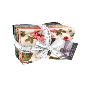 May include: A stack of fabric squares with floral patterns in shades of pink, green, and cream, tied together with a white ribbon and a measuring tape. The fabric is labeled "Moda Fabrics Supplies".