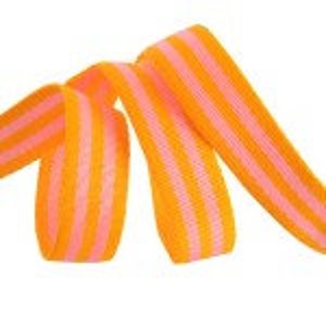 May include: Pink and orange striped candy ribbon. The candy is twisted and folded.