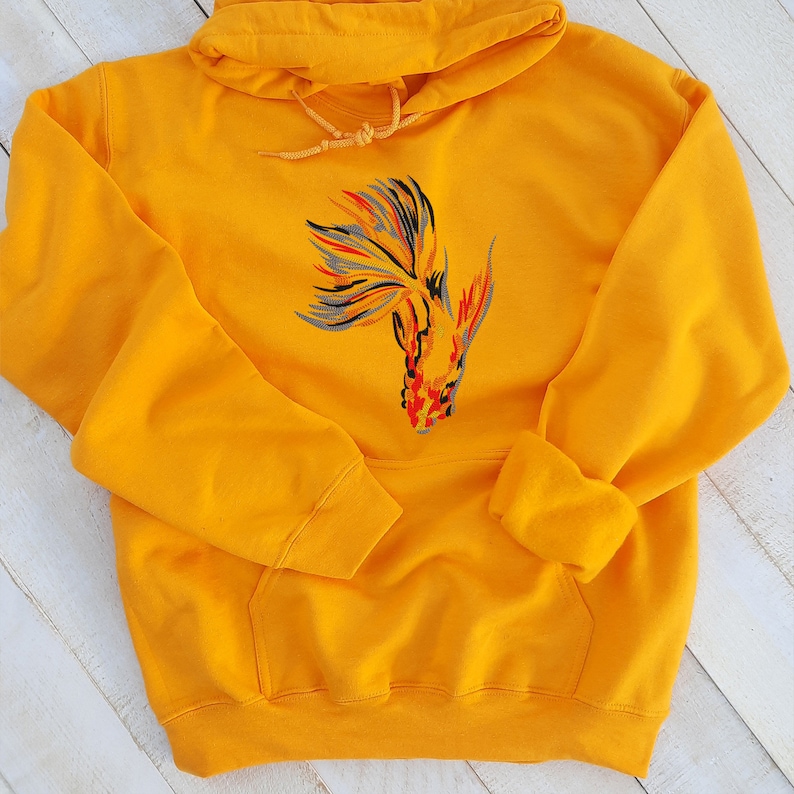 Peut inclure: Un sweat &agrave; capuche jaune avec une image brod&eacute;e d'un poisson rouge color&eacute; sur le devant.