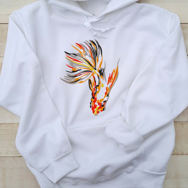 Peut inclure: Sweat-shirt &agrave; capuche blanc avec un motif de poisson rouge brod&eacute; color&eacute; sur le devant.