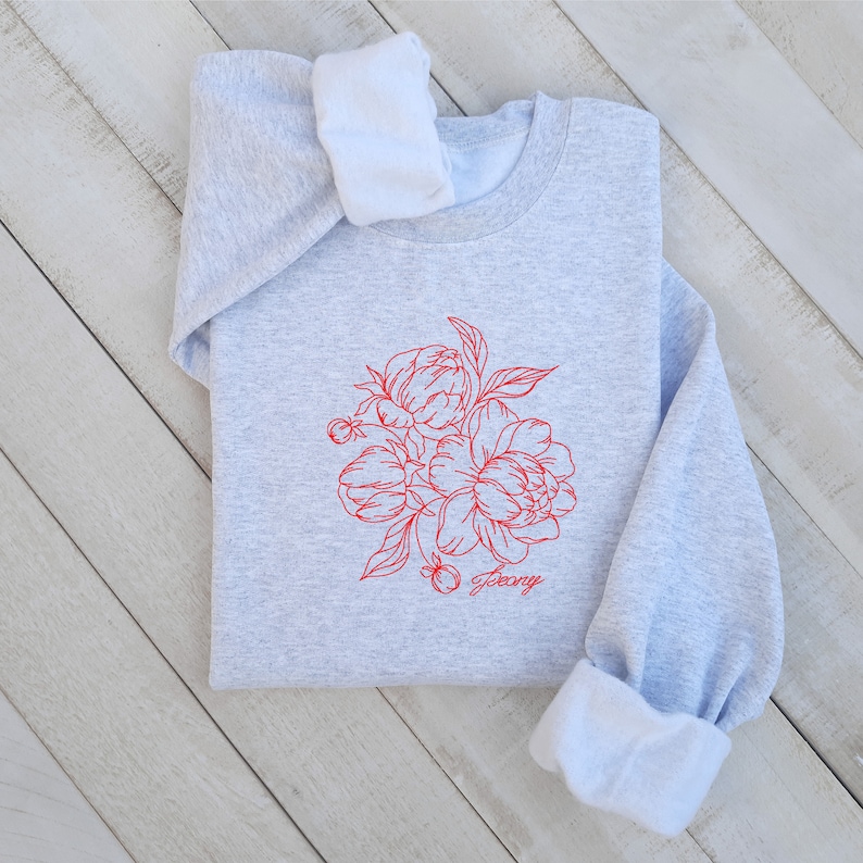 May include: A gray sweatshirt with a red line drawing of a bouquet of peonies and the word "Peony" printed below the flowers.