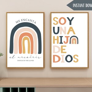 May include: Two framed prints with a rainbow design and Spanish text. The first print says "Me encanta el arcoiris despues de ver llover" and features a rainbow with blue, pink, orange, and yellow colors. The second print says "Soy una hija de Dios" and features a smaller rainbow in the corner.