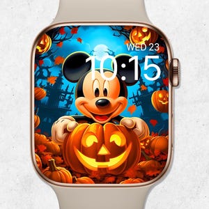 May include: A beige smartwatch with a Halloween-themed display featuring Mickey Mouse holding a carved pumpkin. The screen shows a spooky scene with jack-o'-lanterns, a haunted house, and the time 10:15, with the day of the week and date displayed.
