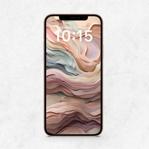 May include: A gold-colored smartphone displays a digital abstract art wallpaper in shades of pink, beige, and gray. The lock screen shows the date and time: Wednesday, 23 February, 10:15.