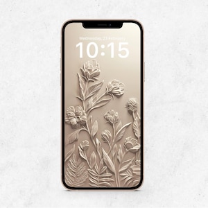 May include: A gold-colored smartphone displays a floral design on its screen. The screen shows a 3D relief of flowers and foliage in a neutral tone, with the date and time displayed at the top. The phone has a sleek, modern design.