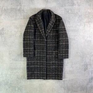 May include: A long, dark grey coat with a plaid pattern. The coat features a notched collar and a single-button closure. The fabric appears to be a textured wool blend, suitable for colder weather.