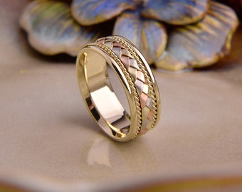 May include: A gold wedding band with a braided design featuring three different shades of gold: yellow, white, and rose.