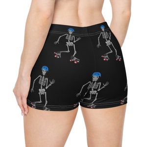 May include: Black athletic shorts with a repeating pattern of skeletons wearing roller skates and blue helmets.