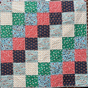 May include: A patchwork quilt featuring a range of floral and butterfly designs in shades of red, blue, green, and white.