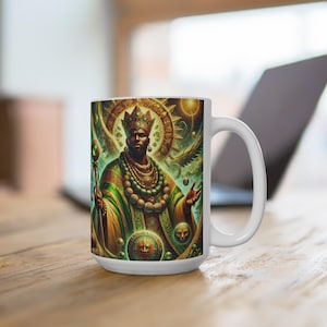 May include: White ceramic mug with a colorful illustration of a king wearing a crown and green and gold robes. The king is holding a staff and is surrounded by a halo of light.