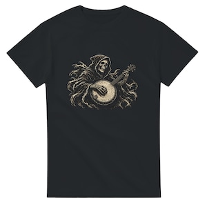 Op de afbeelding: Een zwart t-shirt met korte mouwen en een grafische print van een skelet met een capuchon, gekleed in een gescheurde mantel, terwijl het banjo speelt. De illustratie is uitgevoerd in beige en gebroken witte tinten op de donkere stof.