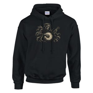 May include: A black hooded sweatshirt featuring a graphic print of a skeleton wearing a hooded cloak and playing a banjo. The skeleton is rendered in shades of beige and off-white, with detailed skeletal hands and a flowing, tattered cloak design.