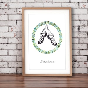 Puede incluir: Una impresión enmarcada con una ilustración de acuarela de un par de zapatos de baile irlandés colgando de un diseño de nudo celta. El texto "Saoirse" está impreso debajo de la ilustración.