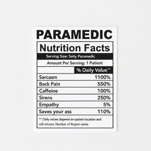 Puede incluir: Una pegatina blanca con texto negro que dice "PARAMEDIC Nutrition Facts". La pegatina enumera los valores diarios de Sarcasmo, Dolor de espalda, Cafe&iacute;na, Sirenas, Empat&iacute;a y Saves your ass.
