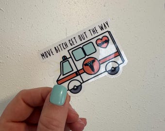 May include: A sticker featuring an ambulance design with the text "MOVE BITCH GET OUT THE WAY." The ambulance has a red and black emblem and a heart graphic. The sticker is held against a white background.