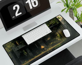 May include: A rectangular desk mouse pad with a forest scene design. The pad is black with a detailed image of trees, a wooden structure, and a soft glow of light. A white keyboard and mouse sit on top of the pad, with a computer monitor in the background.