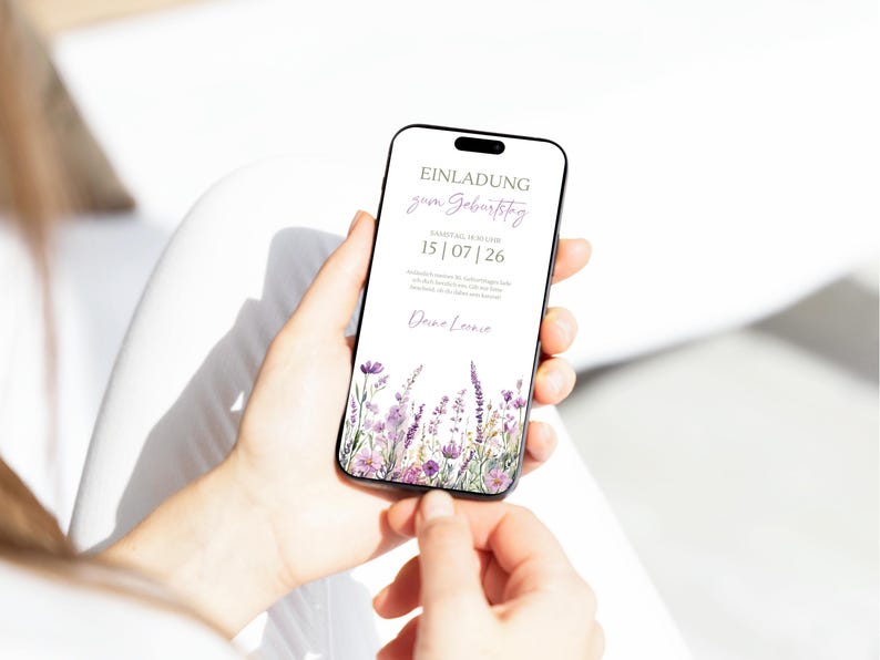 May include: A digital invitation on a smartphone screen with a floral design. The invitation reads "Einladung zum Geburtstag" and "15|07|26".