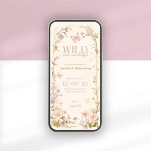 Op de afbeelding: Een smartphone met een digitale verjaardagsuitnodiging met een cr&egrave;mekleurige achtergrond, bloemenrand en vlinders. De tekst luidt: WILD and wonderful, Du bist eingeladen zu Amelies 5. Geburtstag, Samstag, 15:30 Uhr, 12 | 08 | 25, Schmetterlingstra&szlig;e 12, 74507 Blumenstadt, deine Amelie.