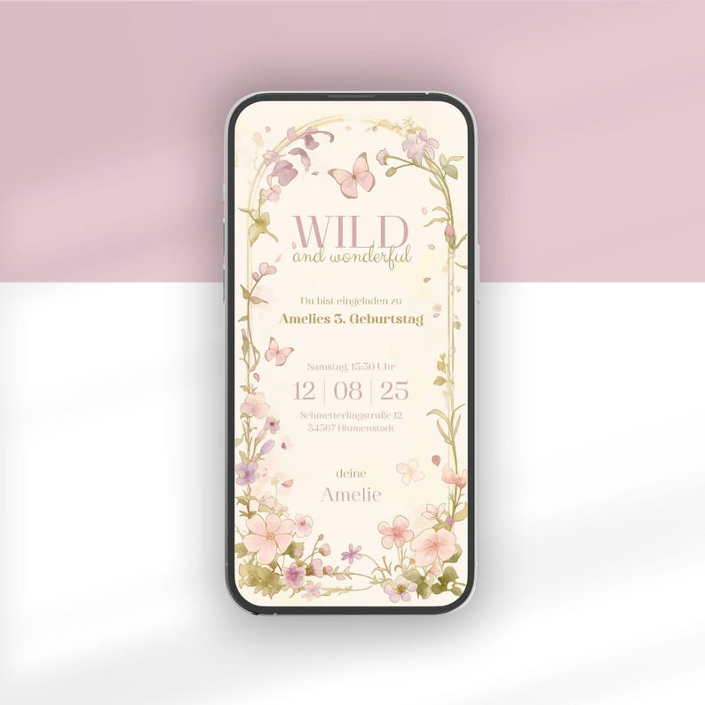 Op de afbeelding: Een smartphone met een digitale verjaardagsuitnodiging met een cr&egrave;mekleurige achtergrond, bloemenrand en vlinders. De tekst luidt: WILD and wonderful, Du bist eingeladen zu Amelies 5. Geburtstag, Samstag, 15:30 Uhr, 12 | 08 | 25, Schmetterlingstra&szlig;e 12, 74507 Blumenstadt, deine Amelie.