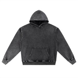 May include: A charcoal gray hoodie with a kangaroo pocket and a drawstring hood. The sweatshirt has a faded, vintage look, with ribbed cuffs and hem. The garment is made of a soft, comfortable material.