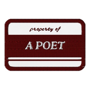 May include: A maroon rectangular patch with white text and accents. The text "property of" is in a cursive font, and the text "A POET" is in a serif font. The patch has a white border and two white horizontal stripes.