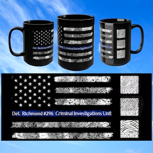 May include: Black coffee mug with a white and blue American flag design. The flag is made up of fingerprints. The text "Det. Richmond #296 Criminal Investigations Unit" is printed on the mug.