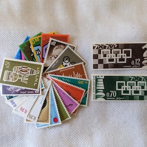 May include: A collection of vintage Israeli postage stamps, featuring various designs and denominations. Some stamps are arranged in a circular pattern, while others are displayed separately. The stamps showcase colorful graphics and text.