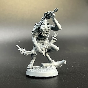 May include: A gray plastic miniature figurine of a creature with a wolf-like head, holding a spear and standing on a base.
