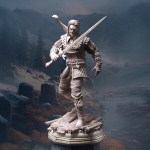 May include: A white painted figurine of a warrior holding a sword. The figurine is standing on a stone base with a detailed design. The background is a blurry image of a snowy landscape.