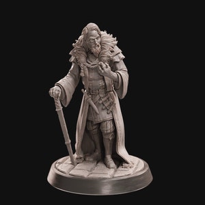 Könnte beinhalten: Eine detaillierte Miniaturfigur eines bärtigen Mannes, der einen langen Mantel trägt und einen Stab hält. Er trägt einen Pelzkragen und hat ein Schwert an seiner Seite. Die Figur ist in hellgrau bemalt und steht auf einem runden Sockel.