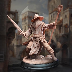 May include: A detailed figurine of a wizard in a long robe and hat, holding a sword and staff. The wizard has a long beard and is standing on a rocky base. The figurine is a light brown color.