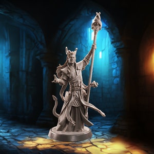 May include: A detailed miniature figurine of a wizard with a staff, horns, and a long flowing robe. The figurine is painted in a light gray color and is standing on a round base. The background is a dark, stone-walled room with two arched doorways.