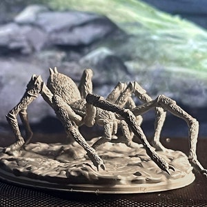 May include: A white, detailed, plastic miniature of a spider with eight legs. The spider is posed on a round base.