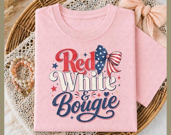 May include: A light pink t-shirt with the words "Red White & Bougie" in a patriotic design. The design includes a bow with red and white stripes and blue stars, along with red and blue stars.