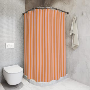 K&ouml;nnte beinhalten: Orange-rosa gestreifter Duschvorhang in einem Badezimmer mit einer wei&szlig;en Toilette.