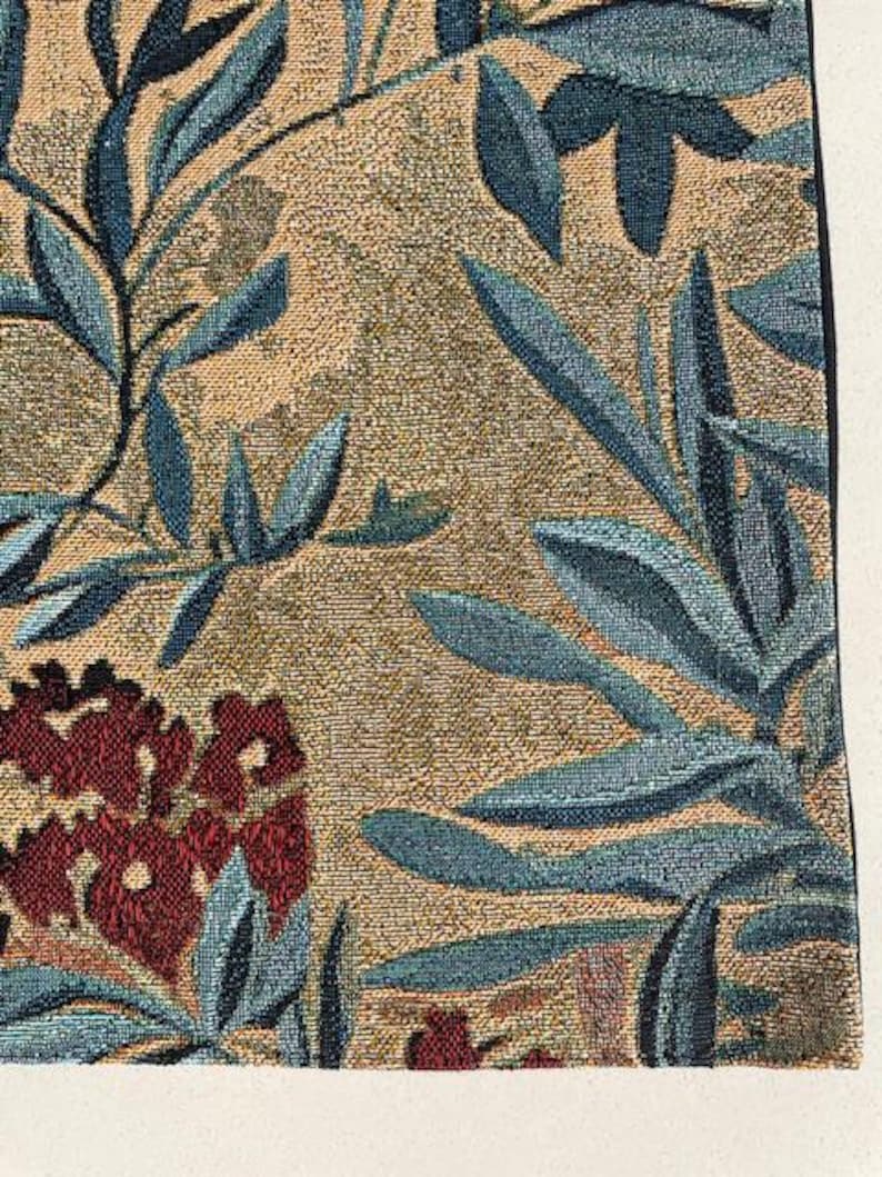 May include: Close-up of a woven textile with a floral pattern. The design features teal leaves and burgundy flowers against a tan background. The fabric has a textured appearance, suggesting a tapestry or upholstery material.