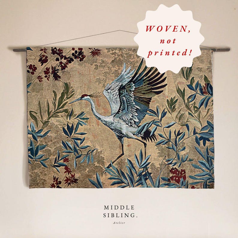 May include: Woven wall hanging featuring a crane with outstretched wings, set against a backdrop of blue and green foliage and floral elements. The text "WOVEN, not printed!" is visible. The words "MIDDLE SIBLING. Atelier" are also visible.