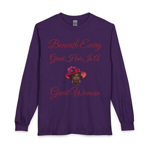 May include: A long-sleeve purple shirt featuring the red text "Beneath Every Great Hat Is A Great Woman" and a graphic of a person wearing a red hat with a pink flower, positioned between the lines of text on the front of the garment.