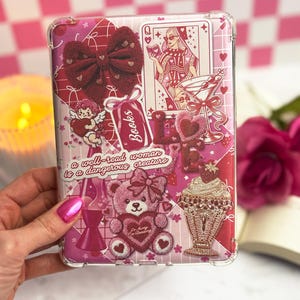 May include: A pink phone case with a collage of decorative elements. Features include a burgundy bow, a Queen of Hearts playing card, a teddy bear, and a sundae. The case has the text "a well-read woman is a dangerous creature."