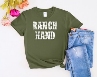 Puede incluir: Una camiseta verde con el texto "RANCH HAND" en letras blancas desgastadas.
