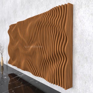 May include: A large, wooden wall panel with a wave-like design. The panel is made of vertical, curved wooden slats, creating a textured, three-dimensional effect. The wood has a warm, natural tone. The panel is mounted on a white wall.