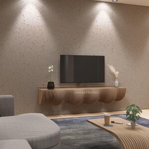 May include: A contemporary living room with a wall-mounted television above a wooden console with a curved design. The room includes a grey sofa, a wooden coffee table, and decorative plants. The wall is a textured, neutral colour.