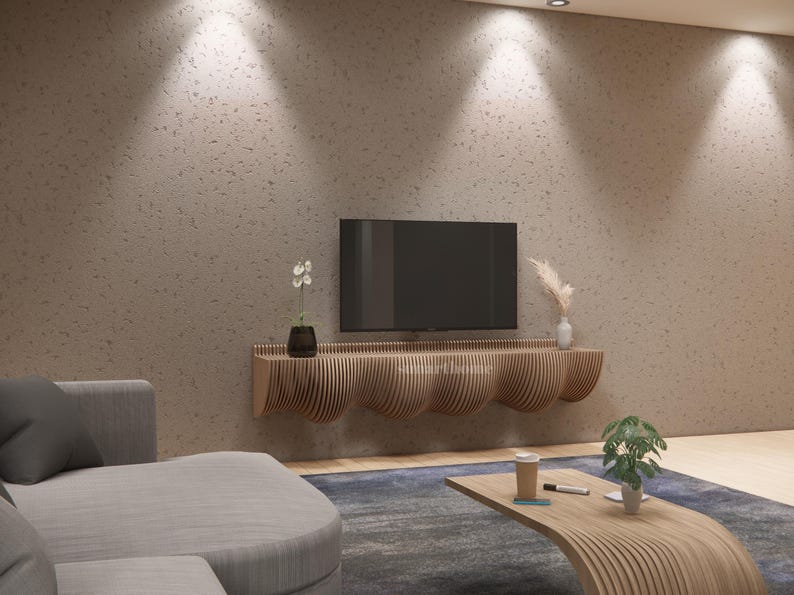 May include: A contemporary living room with a wall-mounted television above a wooden console with a curved design. The room includes a grey sofa, a wooden coffee table, and decorative plants. The wall is a textured, neutral colour.