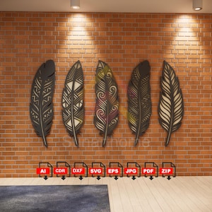 Puede incluir: Cinco piezas decorativas de arte mural de plumas de madera en varios diseños y colores, montadas en una pared de ladrillo. Cada pluma tiene intrincados patrones recortados. Las plumas son en tonos marrón, beige y dorado. En la parte inferior de la imagen se ve una alfombra azul.