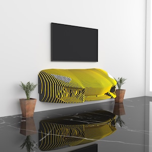 May include: A yellow and black striped TV stand shaped like the front of a car. The stand is mounted on a white wall with a black TV above it. Two potted plants are on the floor.