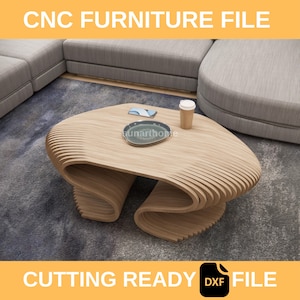 May include: A light-colored, CNC-cut wooden coffee table with a unique, wavy design. The table has a smooth surface and a curved base. The image also includes a plate, a coffee cup, and a phone on the table. Text on the image reads "CNC FURNITURE FILE" and "CUTTING READY DXF FILE".